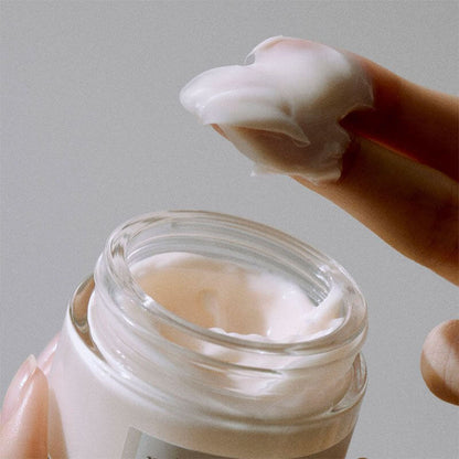 K-beauty fermented bean cream in a jar with a creamy texture on a finger.